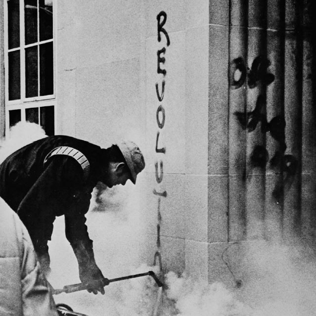 A construction worker cleans graffiti