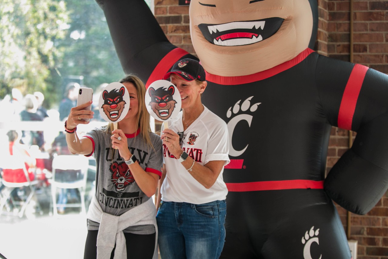 UC alumnae take a selfie in front of inflatable Bearcat