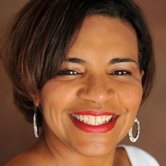 Alumna Rashida Mauel looks onward while deep in discussion