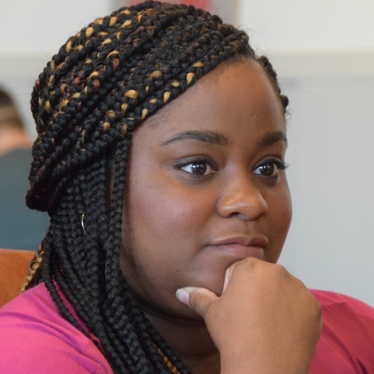 Alumna Rashida Mauel looks onward while deep in discussion