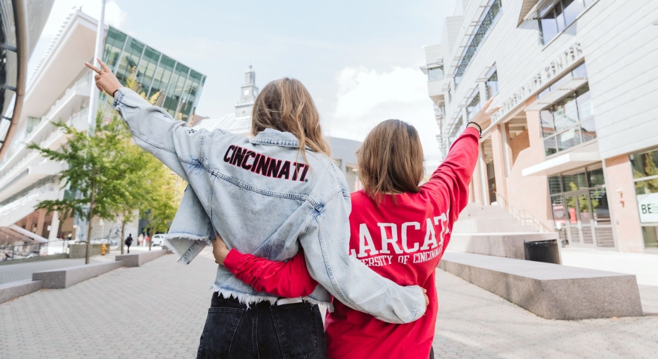 two women wearing UC gear on campus