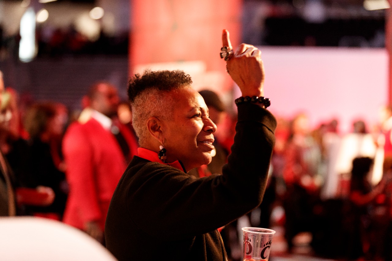 Woman cheers holding a UC cup