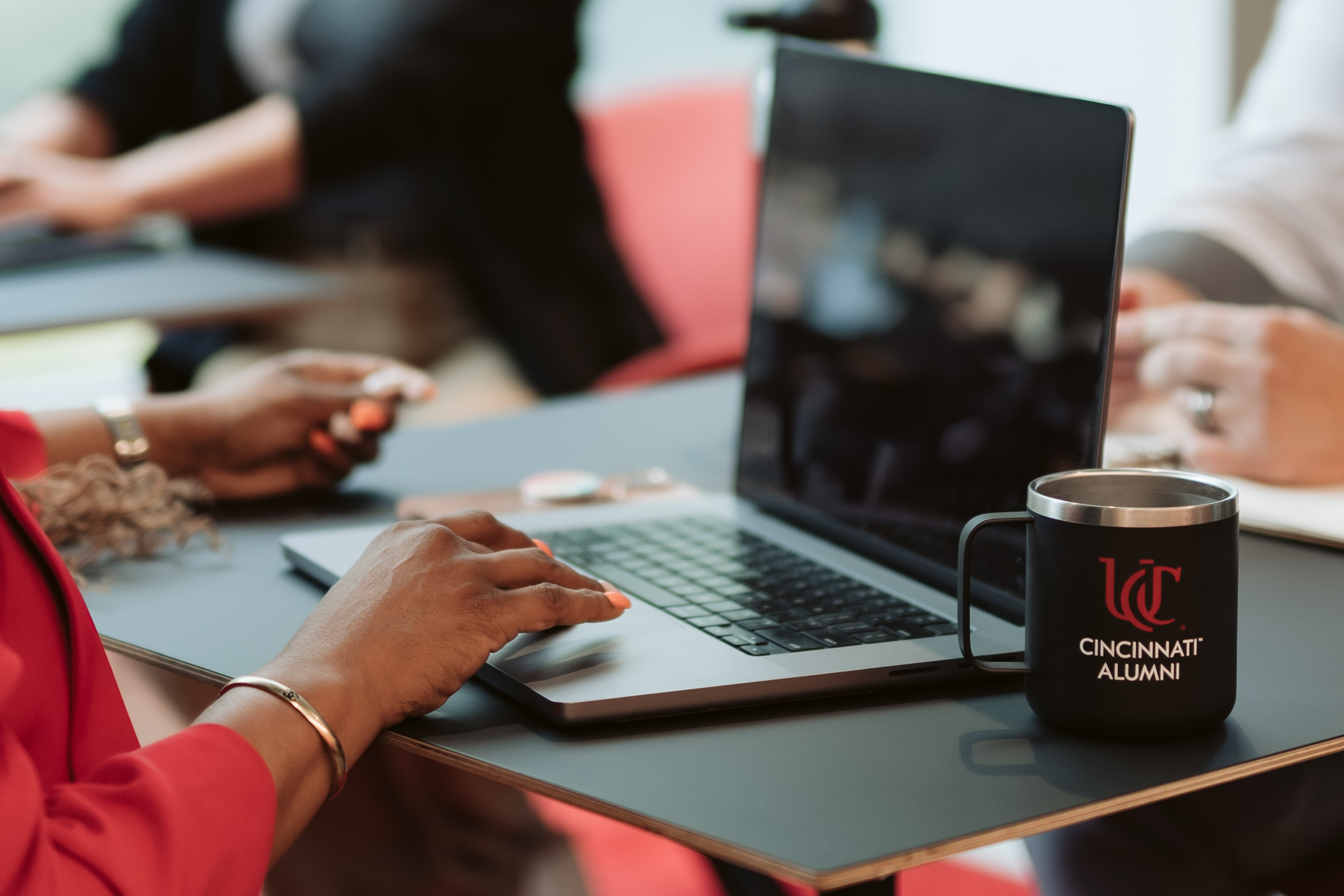 Woman working at a laptop next to a cup of coffee
